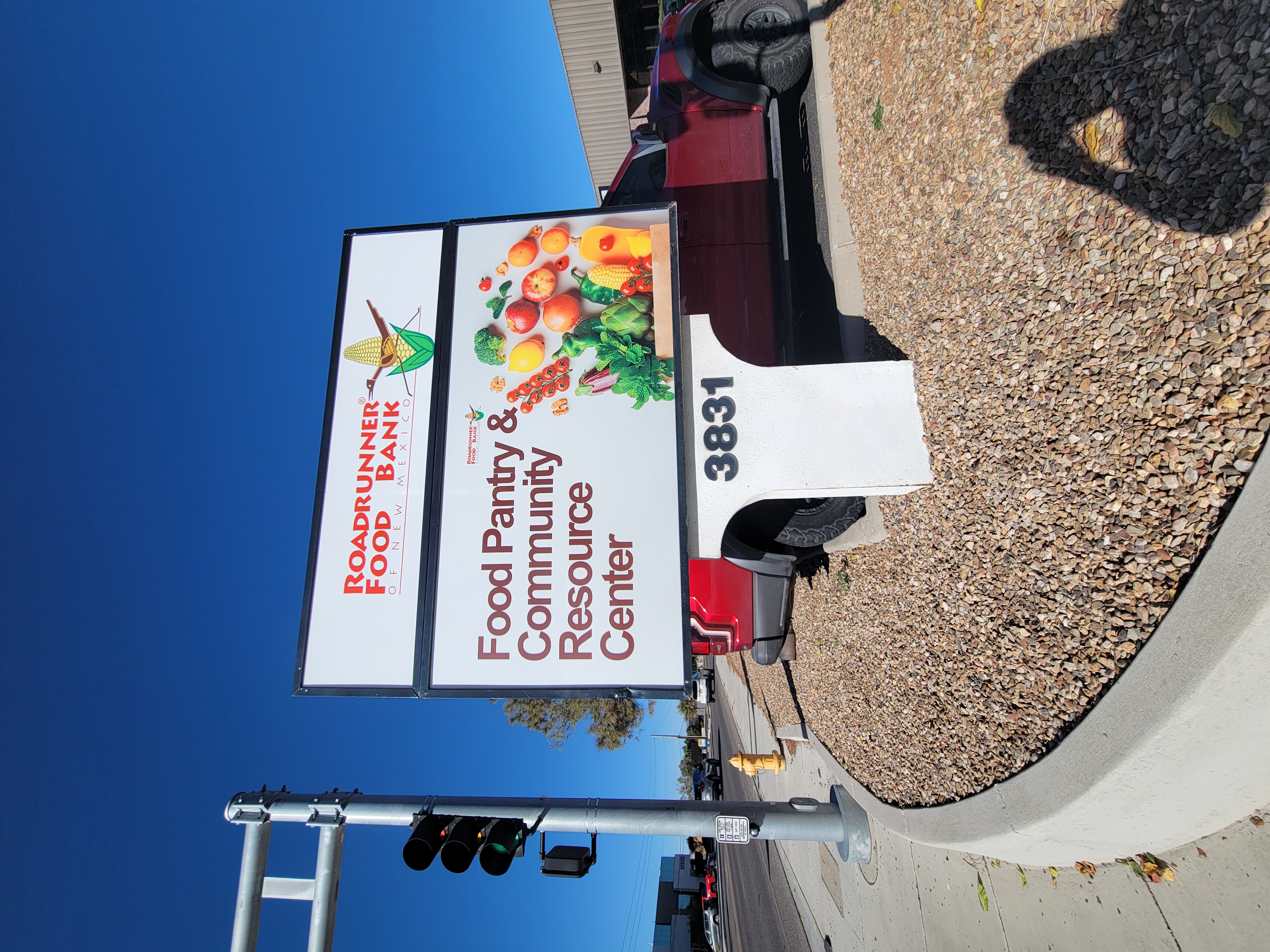 A sign that read food pantry and community resource center and picture of a box spilling out produce next to it .